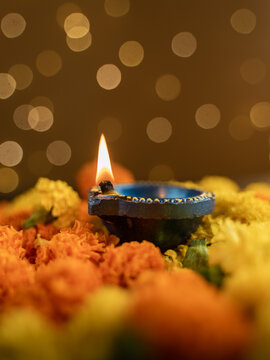Traditional Clay Diya with a Lit Flame Against a Dreamy Warm Golden Bokeh Background, Festive Diwali Close-Up Shot