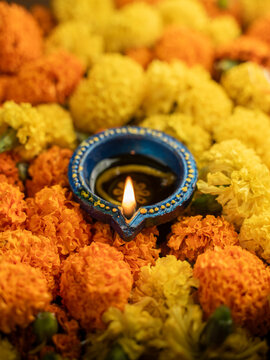 Traditional Clay Diya with a Lit Flame Against a Dreamy Warm Golden Bokeh Background, Festive Diwali Close-Up Shot