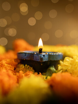 Traditional Clay Diya with a Lit Flame Against a Dreamy Warm Golden Bokeh Background, Festive Diwali Close-Up Shot