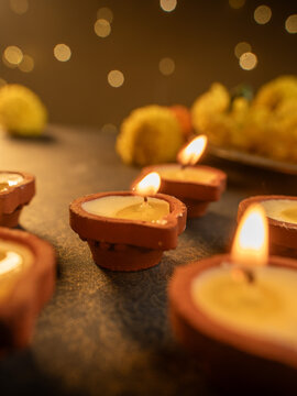 Traditional Clay Diya with a Lit Flame Against a Dreamy Warm Golden Bokeh Background, Festive Diwali Close-Up Shot
