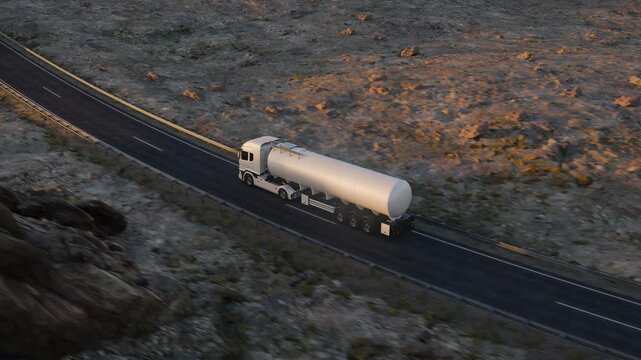 A high rear three-quarter camera pulls upward and away from a white tanker truck, gradually revealing more of the winding road and surrounding rocky desert terrain.