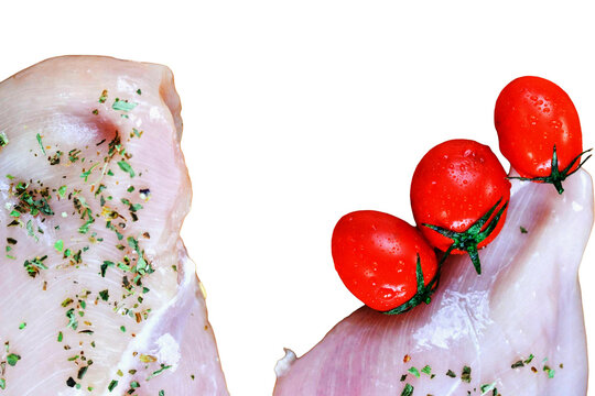 Raw chicken breast seasoned with herbs and fresh cherry tomatoes meat meal prep food preparation culinary art home cooking white background photography product lean protein
