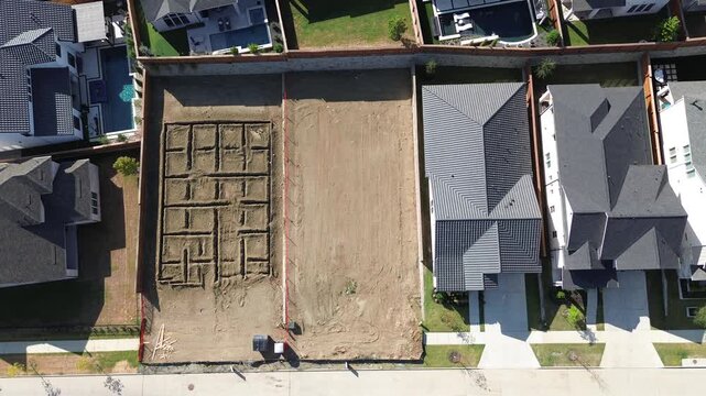 Rectangular building parcels feature precise grade leveling beside dark shingled roofs along Frisco. Suburban roadway curves flank newly established properties across thriving, Texas