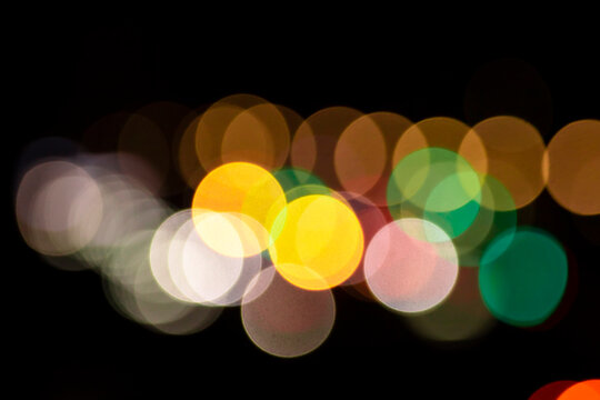 Dense colorful round bokeh lights texture overlap, abstract vibrant night city background with bright neon circles, festive winter holiday celebration atmosphere for creative digital art.
