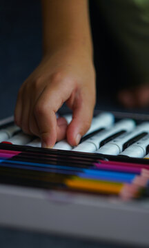 Little girl hand choosing a marker pen from an art kit.