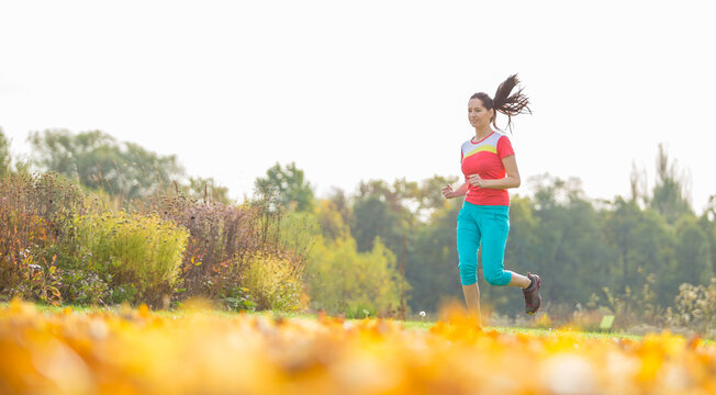 Woman Running in a Colorful Autumn Park