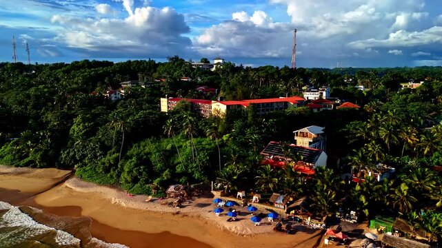 Aerial view of Madiha Beach with golden sand, palm trees, and coastal buildings in Matara, Southern Province, Sri Lanka.