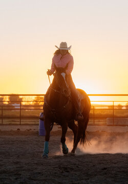 Horseback riding at sunset in an outdoor arena