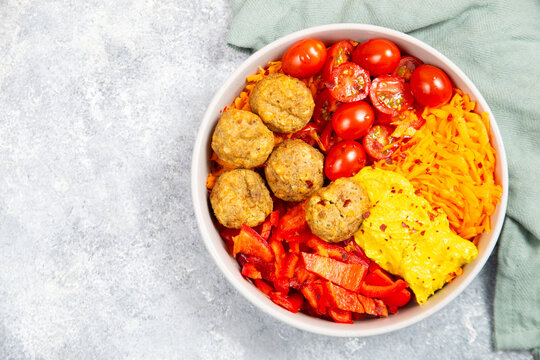 Salad bowl with falafel, cherry tomatoes, shredded carrots, red bell pepper and hummus dip, meaditerranean or middle eastern food, healthy eating