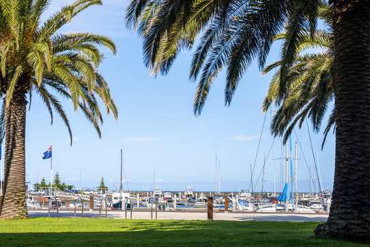 Docked sailboats, motorboats, and yachts moored at the Wyndham Harbour marina in Werribee South, Melbourne, Australia. Recreational marina facilities for leisure boating and waterfront promenade