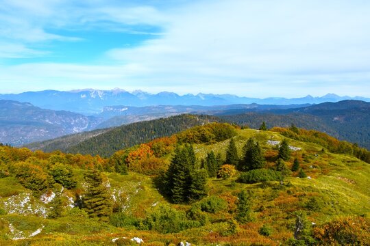 Meadows and trees bellow Možic with forest covered Jelovica plateau and Karavanke mountains in Gorenjska, Slovenia