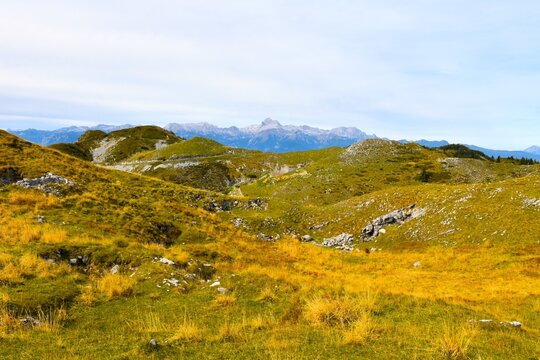 Pasture covered hills near Možic hill with Triglav mountain peak in the distance in Julian alps, Gorenjska, Slovenia