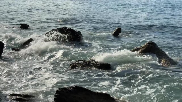 High Angle View of White Sea Waves Crashing on Dark Coastal Rocks