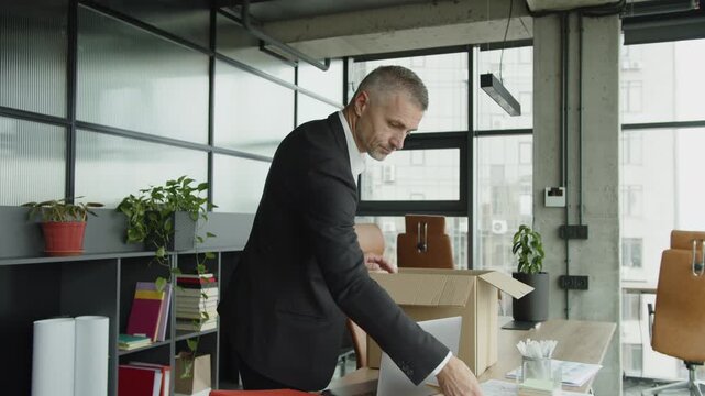 Fired man packing box with his personal stuff in office. Businessman got fired from job. Taking box with personal stuff from office. Man by dismissal. Guy lost job. Fired manager in company