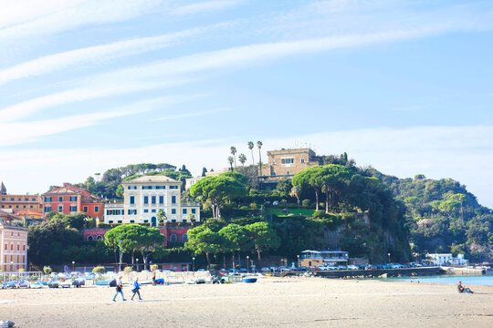 Wide sandy beach Sestri Levante Italian Riviera historic villas hill. Mediterranean resort lifestyle lush green pines coastal relaxation. Luxury hospitality holiday booking travel destination concept.
