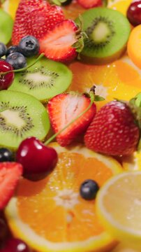 Background of fresh fruits and berries rotating. Vegan sweet food, flat lay.
