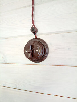 Vintage light switch on a white wooden wall, closeup of photo