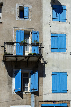 Colorful french houses on the central square of Quillan (Aude, France) with traditonal window shutters and an iron balcony railing