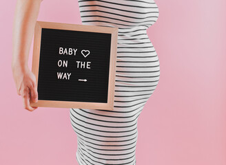 woman holding a board with a message about pregnancy © Skyblue Creative