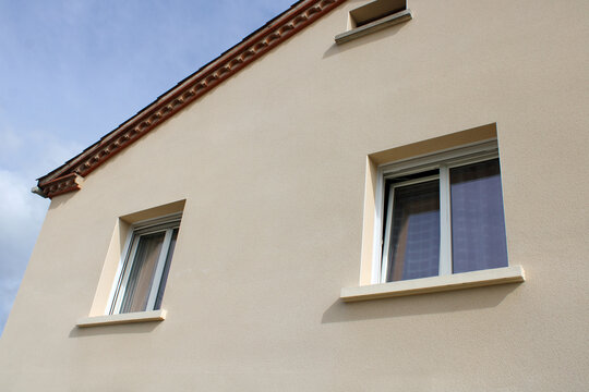 Fa&ccedil;ade de maison avec fen&ecirc;tre en PVC blanc ouverte en position oscillobattante