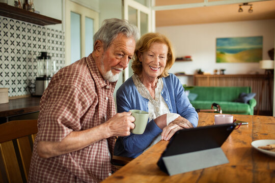 Senior couple using tablet at kitchen table