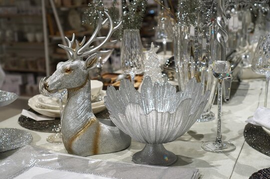 Vintage silver deer figurine and retro glassware for festive table setting in a shop. Antique-style dishes, crystal wineglasses and nostalgic decor for Christmas and New Year home celebration.