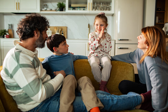 Girl telling a story to her family on the sofa