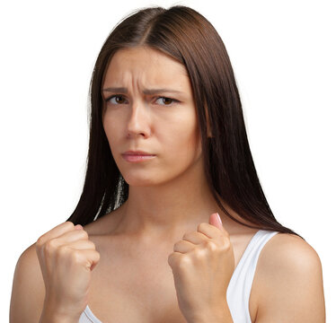 Woman raising clenched fists and frowning during a studio portrait against a white background