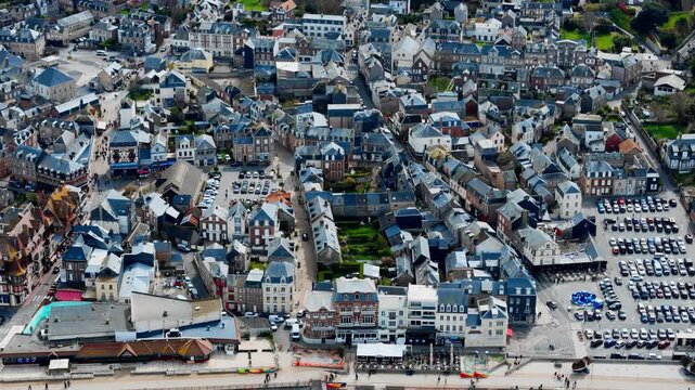 Etretat town center in Normandy, France, from drone. Traditional architecture, narrow streets and seafront promenade in French seaside destination.