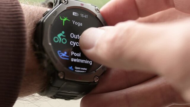 Man selecting workout menu on rugged smartwatch close up
