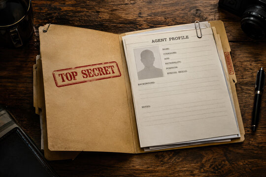 Top secret agent profile dossier on a wooden desk with confidential documents, a paper clip, pen, camera, and coffee cup, evoking espionage, mystery, and intelligence investigation