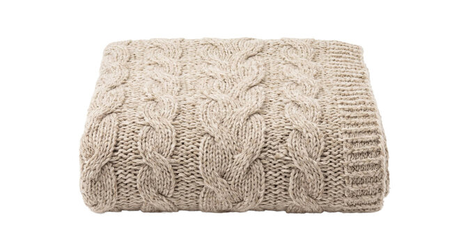Folded beige cable-knit blanket with chunky braided texture isolated against a dark background