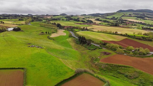 Rural landscape of Azores with green fields, hills, aerial top view on overcast day