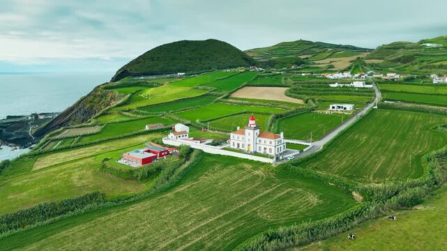 Ferraria Lighthouse stands in lush farmland on Sao Miguel, Azores, Portugal, close to Atlantic coast