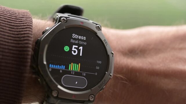 Close-up of rugged smartwatch on wrist showing real-time stress level and graph