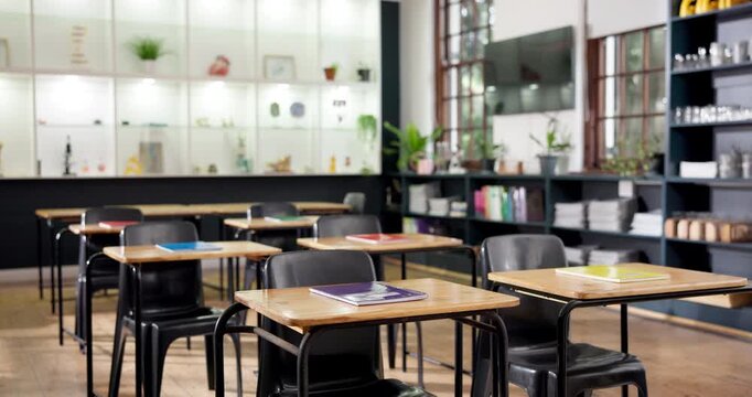 Education, notebook and desk in classroom for learning, study material or research in empty college. Stationery, campus or table in school for growth, development or scholarship opportunity in lesson