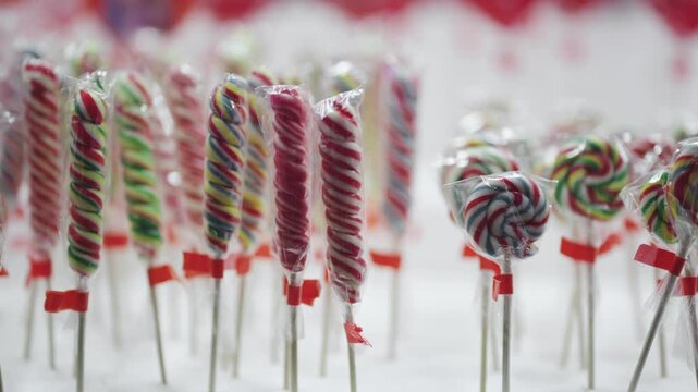 Brightly colored lollipops are attractively displayed in packages, creating a cheerful and festive atmosphere
