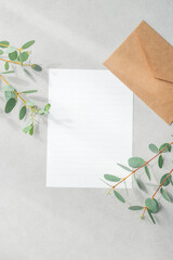 Blank Lined Letter Paper and Kraft Envelope with Eucalyptus Leaves on Textured Greige Background © 清美 小池