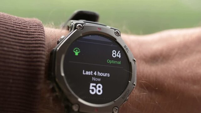Close-up of rugged smartwatch on wrist showing body energy score and optimal status