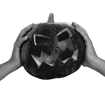 Hands hold a carved pumpkin with angular eyes and a wide, jagged mouth against a transparent background, presenting a Halloween decoration with no specific location or time shown.