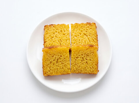 Traditional Indonesian sweet honeycomb cake Bika Ambon sliced on white plate isolated on white background