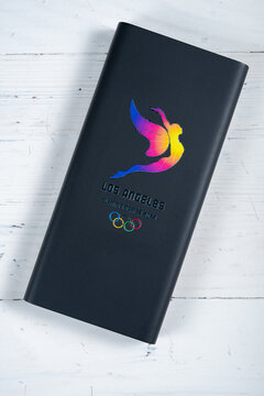 ZhongShan GuangDong China-May 4 2026: Black Los Angeles 2028 Olympic power bank resting on white wooden planks.