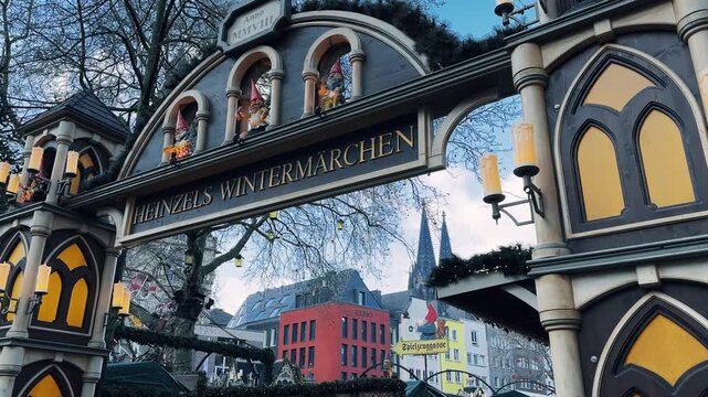 A large archway entrance to Christmass market in Cologne with background view of Dom cathedral