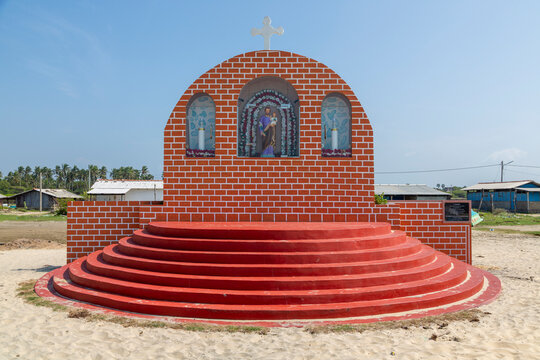 Red brick Catholic shrine with a statue of a saint holding a child, Northern Province, Mannar, Sri Lanka