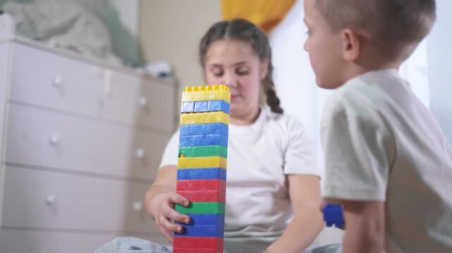Two children playing with blocks. A group of children blocks are assembling a construction. A group of kids play with toys. Two kids stacking lifestyle.