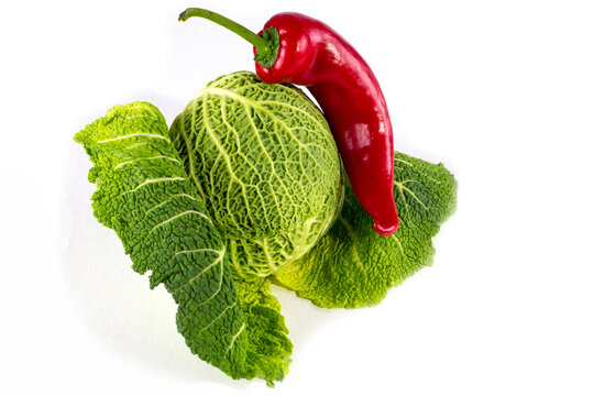 Head of Savoy cabbage and red sweet pepper on a white background