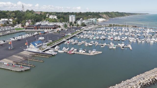 Port Washington, Wisconsin, United States - 23 September 2026: Aerial view of boats docked in the marina with a stone breakwater and shoreline buildings.
