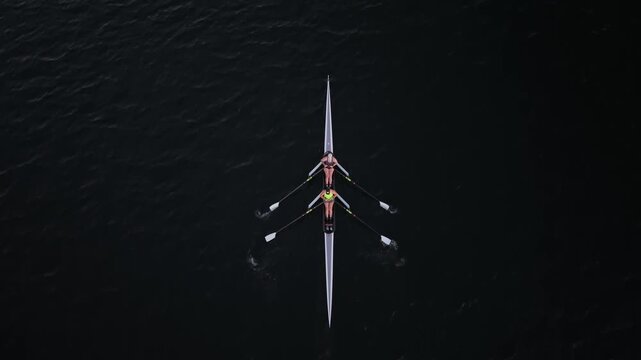 Cinematic aerial footage of Halifax Harbour at sunrise, capturing athletes in single and double rowing boats practicing their strokes across the calm Nova Scotia waters.