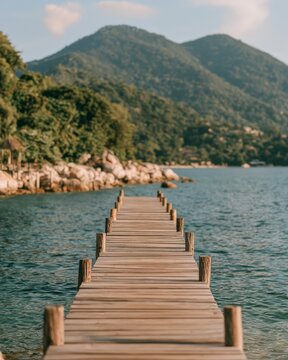 Wooden jetty leading across a lake toward green mountains
