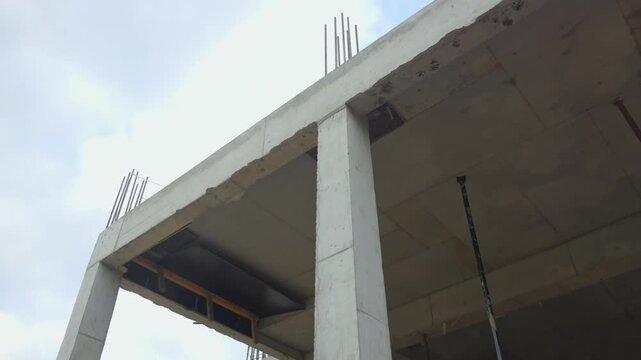 Concrete columns and ceiling slabs form multi level building frame. Temporary wooden supports show active floor slab pouring stage